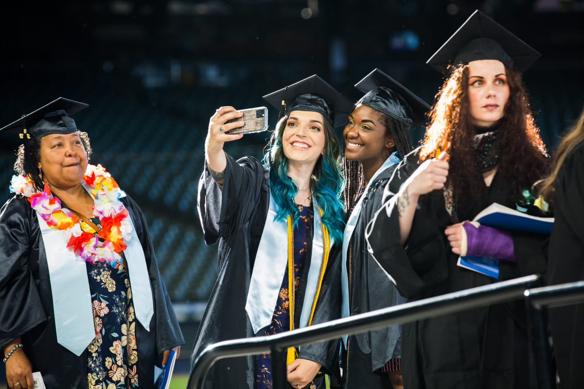 student taking a selfie with a friend just before walking across the stage