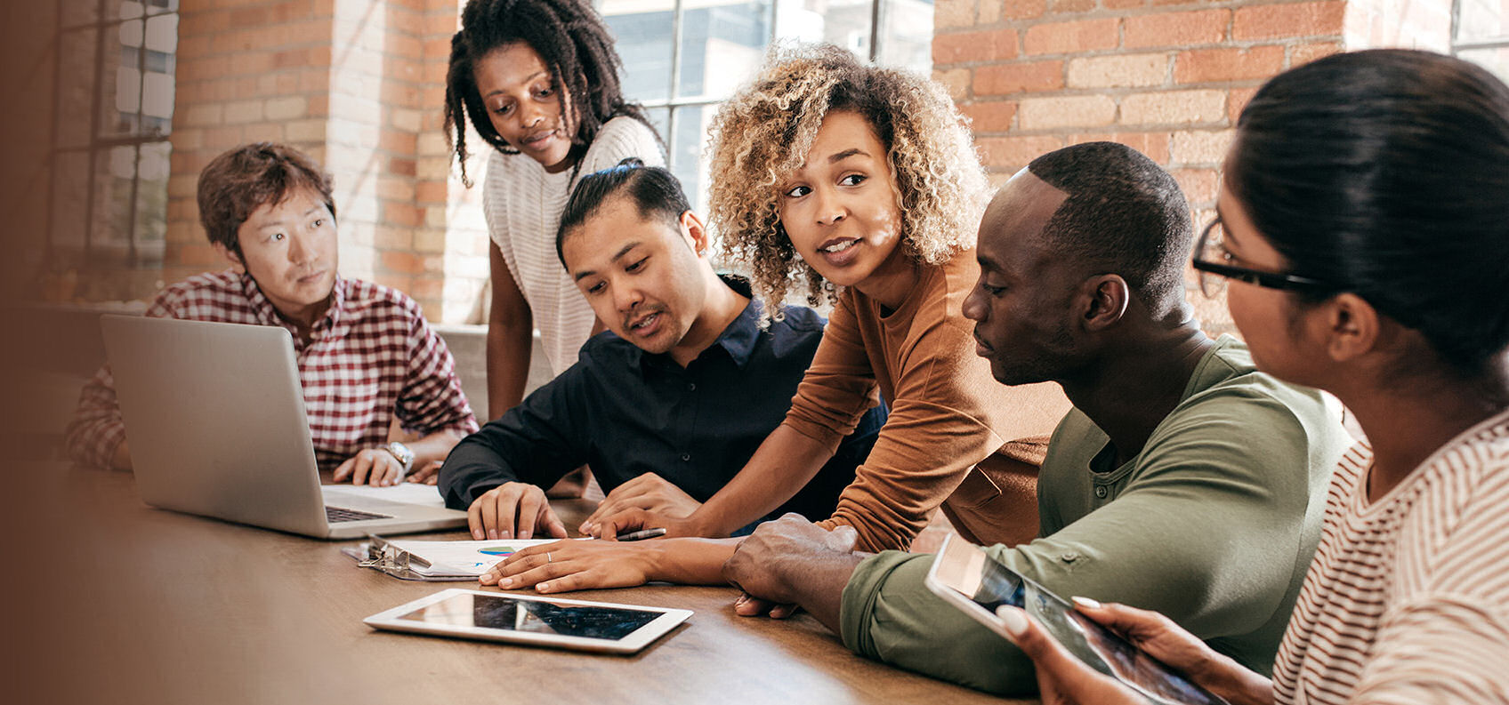  a group of six people of diverse backgrounds at a table in discussion at a meeting setting 