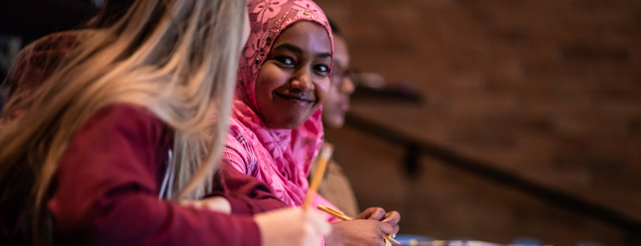  classroom setting with a smiling student wearing a hijab 