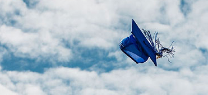 A graduation cap and tassel tossed into the air