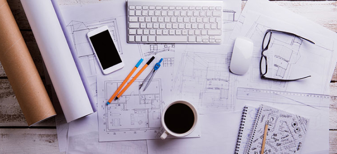 White and grey items on desk with cup of black coffee