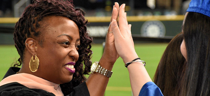 faculty member and student high-fiving