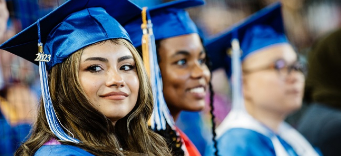 Three graduates in caps and gowns.