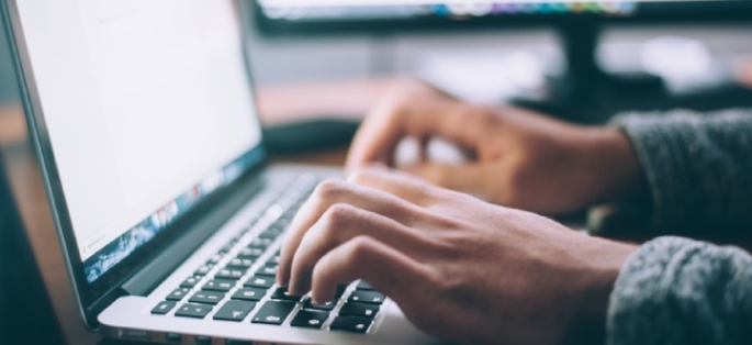 hands typing on a laptop computer