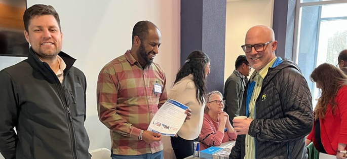 Students at an open house event smiling