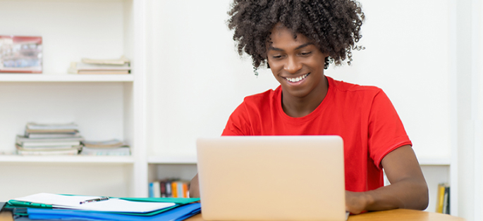 Student on a computer smiling