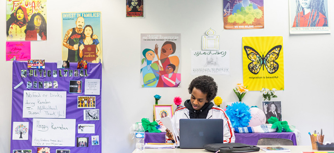 North Seattle student studying in lounge with nice bright posters on the wall