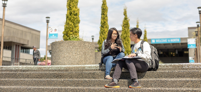 North Seattle College students sitting on front steps