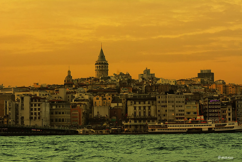 Galata Tower in Turkey with orange sky in the background.