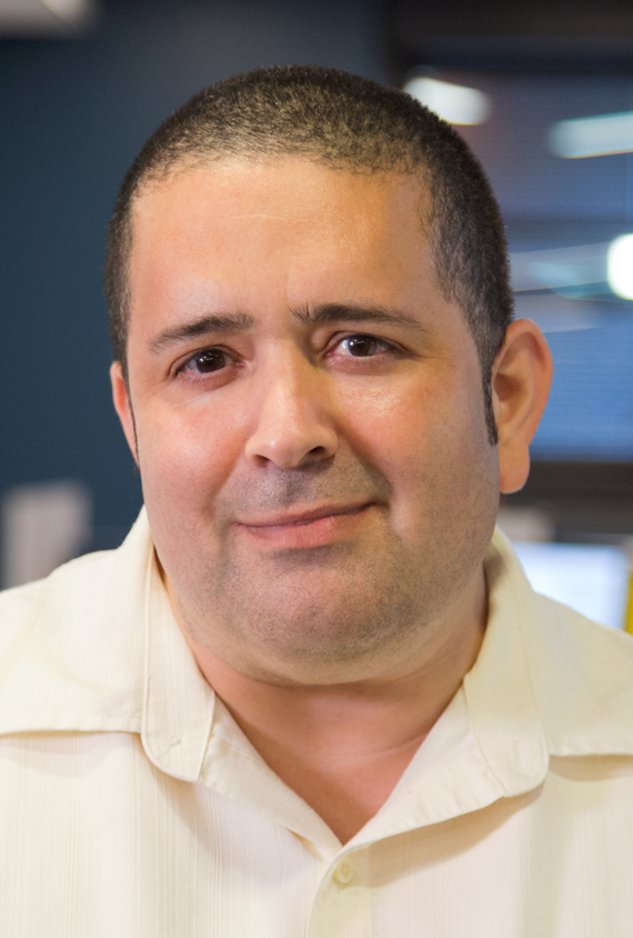 Close up of Shawn wearing a white shirt looking directly into the camera.