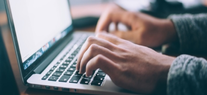 Hands typing on a computer keyboard