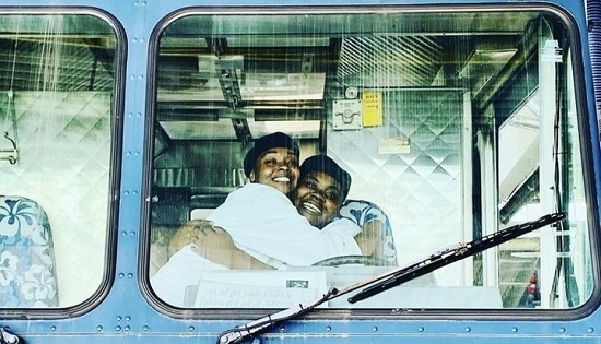 Two students giving each other a hug inside the food truck